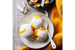 Image Bowl of coconut ice cream scoops with mango sauce, served with tropical fruit pieces